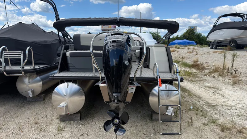 Slide: The Image of A 2027 Starcraft EX 20 Q DH pontoon boat with an outboard motor and ladder at the rear. - 5