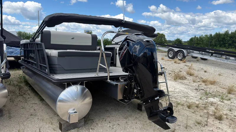 Slide: The Image of A 2027 Starcraft EX 20 Q DH pontoon boat with a black outboard motor and gray seating. - 6