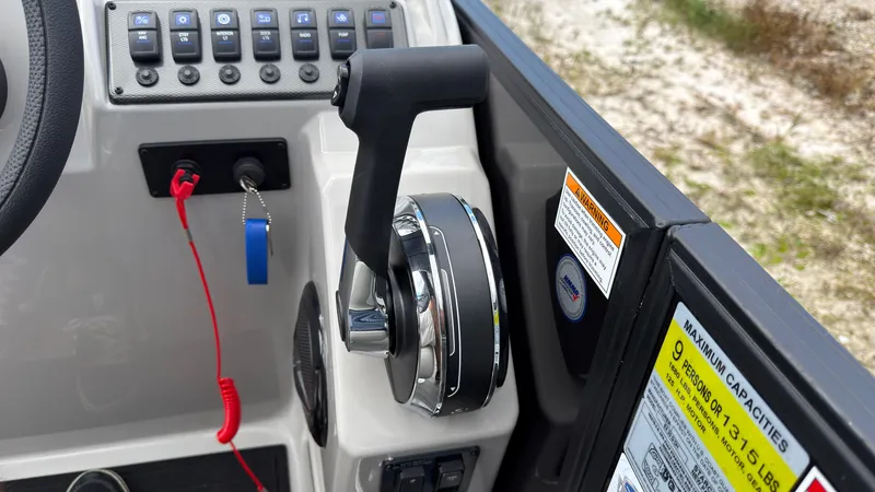 Slide: The Image of Close-up of a boat throttle lever with switches and a safety cord. - 38