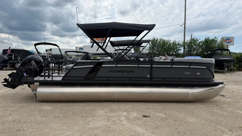 The Image of The image shows a 2027 Starcraft EXS 3 DL pontoon boat with a black canopy and silver hull. - 0