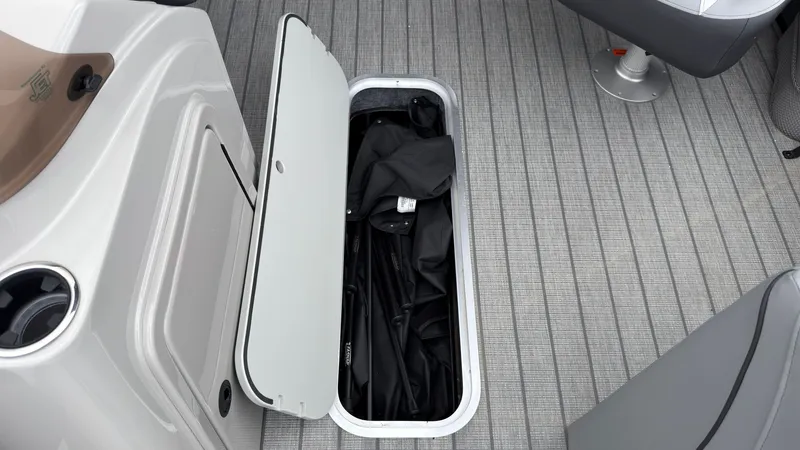 Slide: The Image of An open storage compartment in a boat's floor reveals a black cover or tarp. - 25