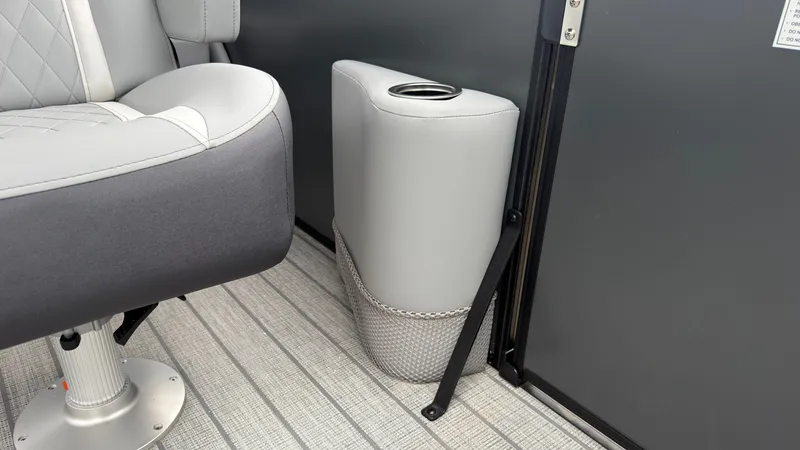 Slide: The Image of A gray seat with quilted pattern next to a cup holder on a boat. - 32