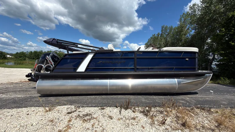 The Image of A 2027 Starcraft EX 20 Q DH pontoon boat is on dry, gravelly ground. - 0
