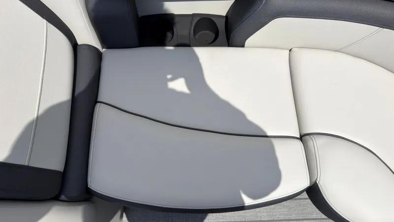 Slide: The Image of Close-up of a white boat seat with black stitching and cup holders. - 20