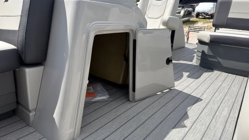 Slide: The Image of An open storage compartment on a boat with gray flooring and seating. - 26