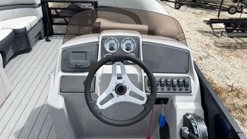 Slide: The Image of The image shows the helm of a Starcraft EX 20 Q DH boat. It features a modern steering wheel and gauges. - 35