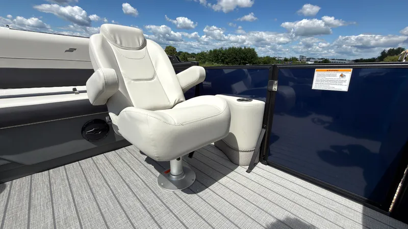 Slide: The Image of A luxurious white captain's chair on a boat with blue railing and gray flooring. - 32