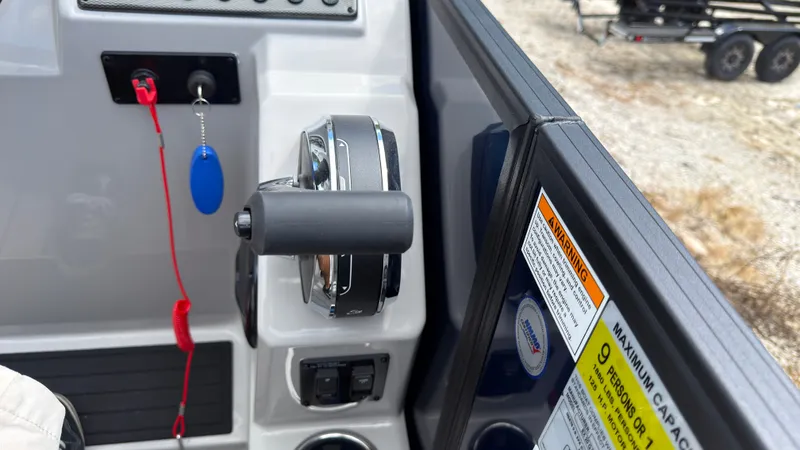 Slide: The Image of Close-up of a boat throttle lever with warning labels and keys. - 40