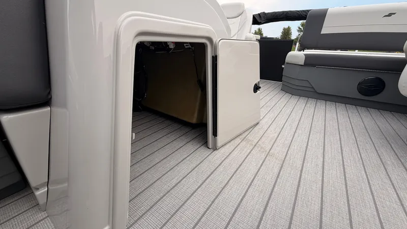 Slide: The Image of The image shows the interior of a 2027 Starcraft EX 20 Q DH boat with gray flooring and storage space. - 24