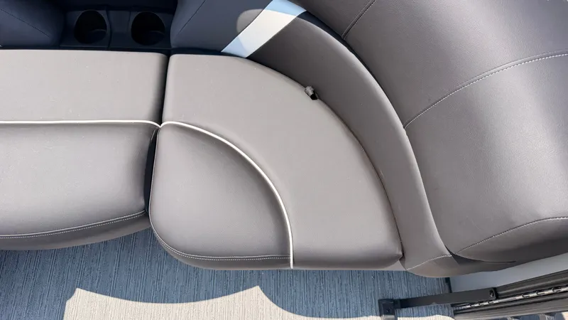 Slide: The Image of Gray upholstery on a boat seat with white stitching and cup holders. - 11