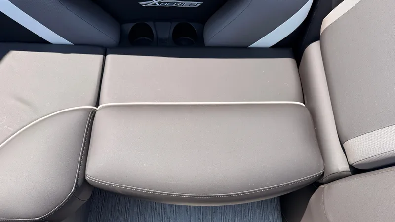Slide: The Image of Close-up of a gray seating area with cushioned seats and cup holders. - 47