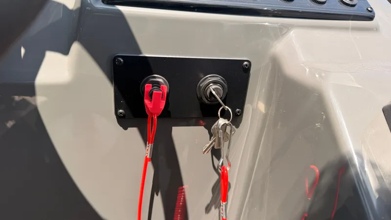 Slide: The Image of Close-up of a boat ignition key and safety switch with red cords. - 39