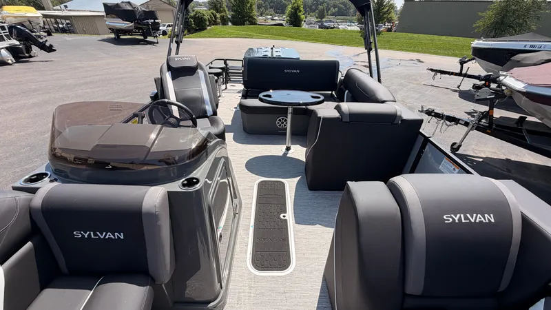 Slide: The Image of The image shows the interior of a Sylvan MIRAGE X3 DLZ BAR pontoon boat with luxurious seating and a table. - 22
