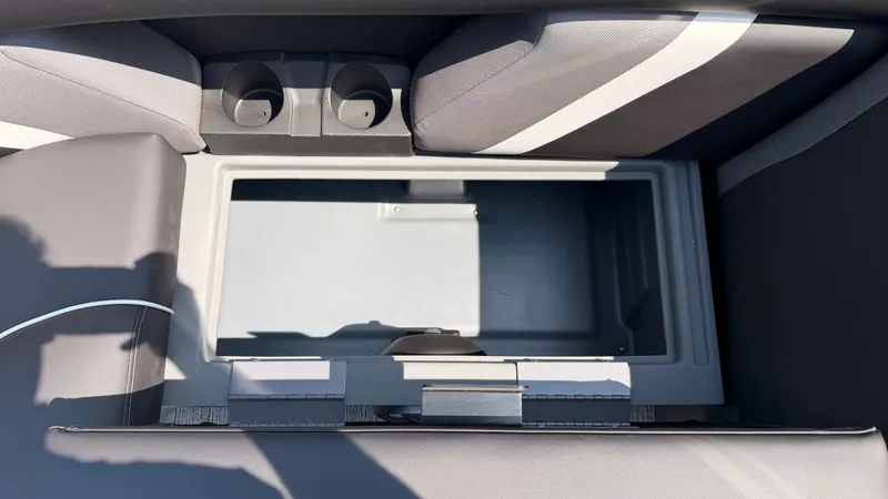 Slide: The Image of An open storage compartment on a Sylvan MIRAGE X3 DLZ BAR boat, surrounded by gray upholstery. - 20