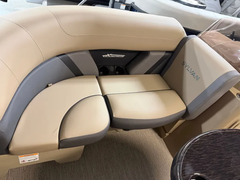 Slide: The Image of The image shows a beige and gray seating area in a Sylvan boat, model MIRAGE X1 CLZ DH. - 2