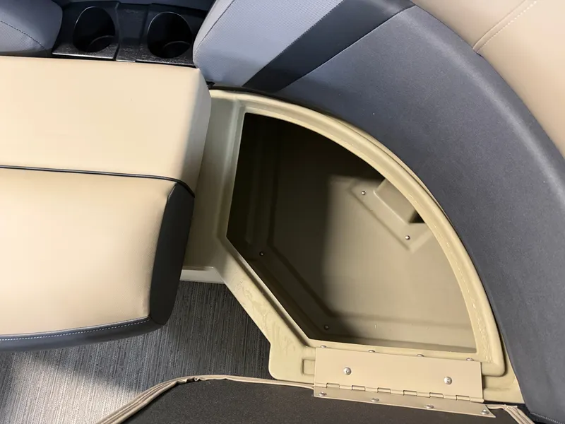 Slide: The Image of An open storage compartment in a boat with beige upholstery and cup holders. - 6
