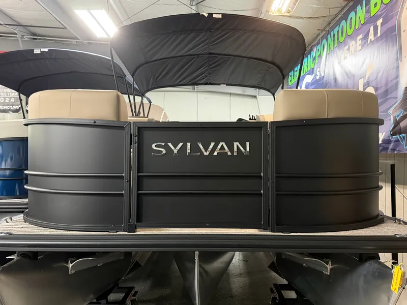 The Image of The image shows the rear of a Sylvan MIRAGE X1 CLZ DH pontoon boat in a showroom. - 0