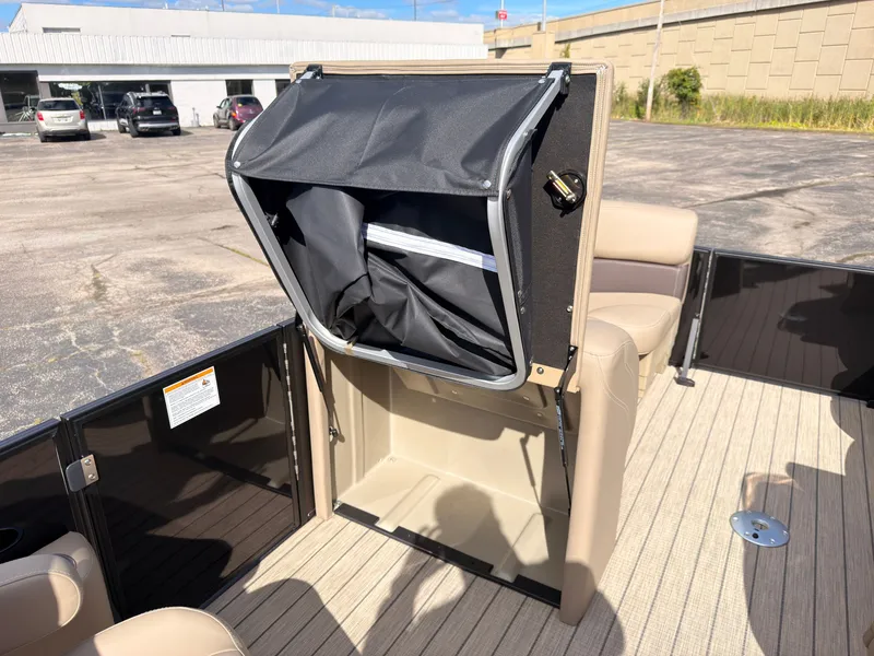 Slide: The Image of An open storage compartment with a black cover on a boat. - 34