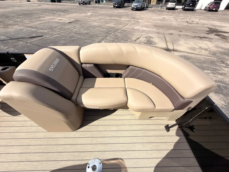 Slide: The Image of The image shows the beige and brown seating of a Sylvan Mirage 8520 CLZ DH boat. - 12