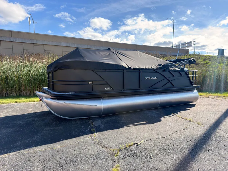 The Image of A 2027 Sylvan Mirage 8520 CLZ DH pontoon boat with a black cover on a parking lot. - 0