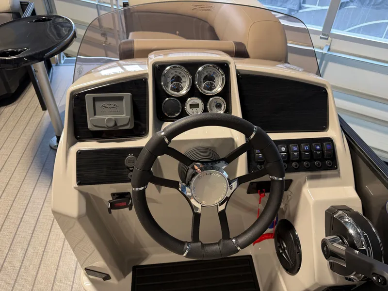 Slide: The Image of The image shows the helm of a Sylvan Mirage 8520 CLZ DH boat with modern instruments. - 10