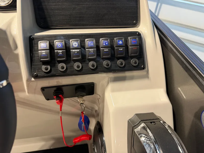 Slide: The Image of The image shows the dashboard of a Sylvan Mirage 8520 CLZ DH boat with various switches and an ignition key. - 12
