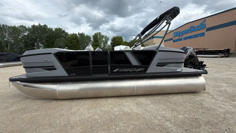 The Image of A gray Starcraft VX 20 Q DH pontoon boat on a gravel lot in front of a building. - 0