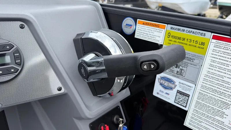 Slide: The Image of Close-up of the throttle lever on a Starcraft VX 20 Q DH with capacity notices. - 38