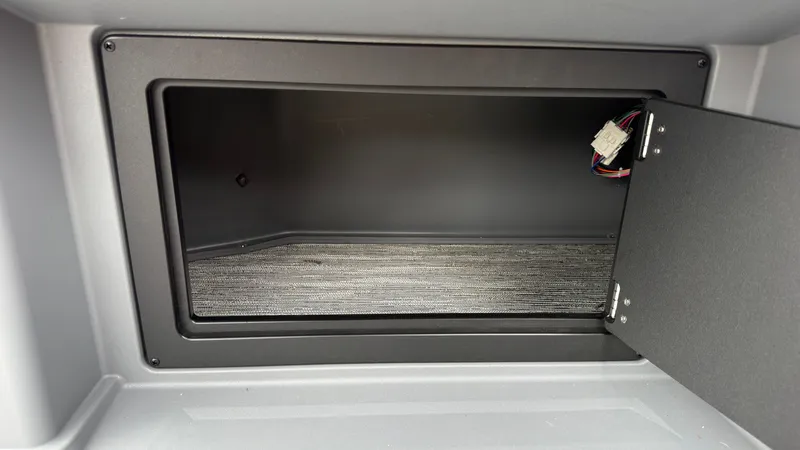 Slide: The Image of An open storage compartment with carpeted flooring and visible wiring. - 41