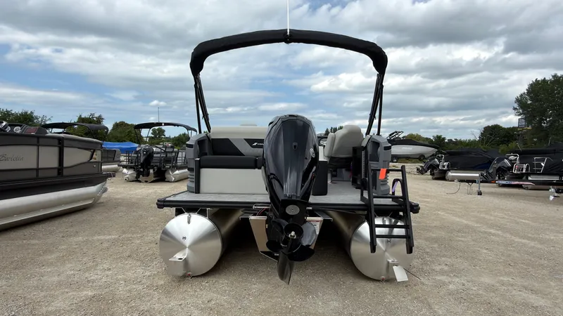 Slide: The Image of A 2027 Starcraft VX 20 Q DH pontoon boat with an outboard motor, parked on a gravel lot. - 6