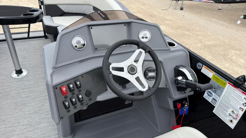 Slide: The Image of The image shows the helm of a Starcraft VX 20 Q DH boat with modern instruments and a sleek steering wheel. - 32