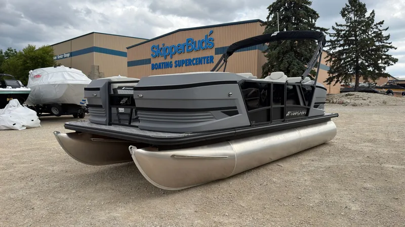 Slide: The Image of A gray pontoon boat is parked on gravel in front of a building labeled "SkipperBud's Boating Supercenter." - 12