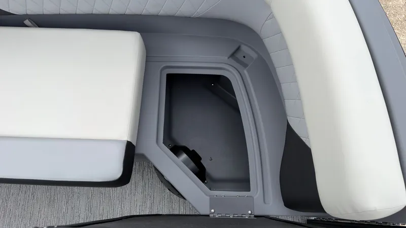 Slide: The Image of A gray storage compartment with cushioned white seats in a boat. - 23