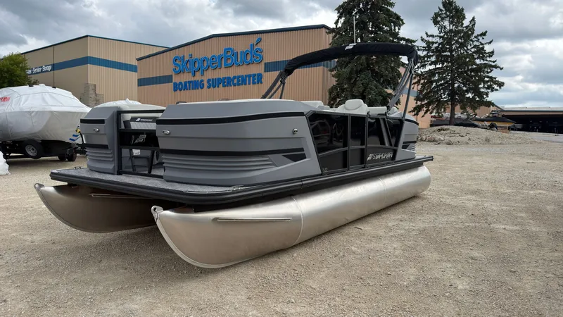 Slide: The Image of A gray Starcraft VX 20 Q DH pontoon boat is parked on gravel in front of a boating store. - 2