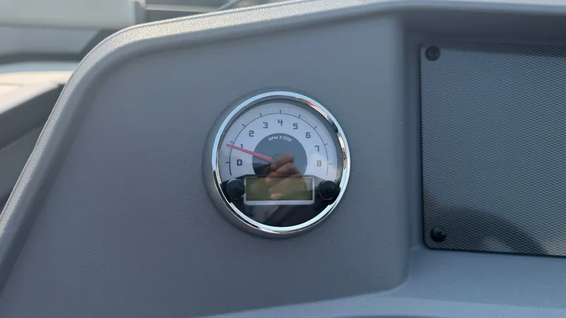 Slide: The Image of Close-up of a tachometer on a boat, surrounded by a gray dashboard. - 27