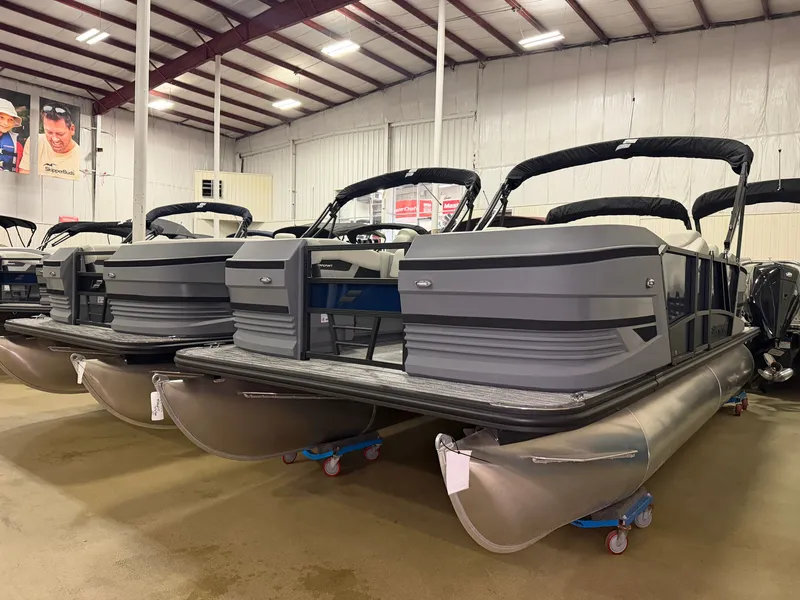 The Image of A modern pontoon boat with a gray hull and black canopy is in a warehouse. - 0