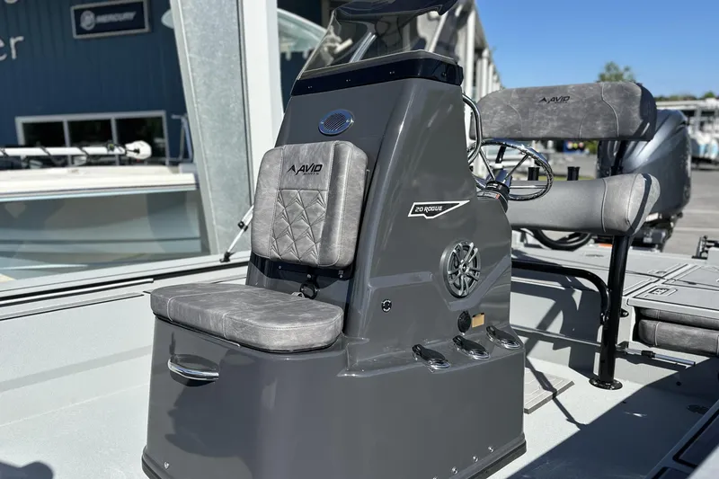 Slide: The Image of Avid 20 Rogue CC 2026 boat console with gray seating and steering wheel. - 9