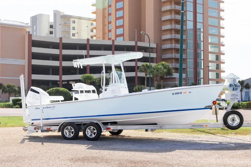 The Image of 2026 Albury Brothers 23 Forward Seating boat on trailer, parked near modern buildings. - 0