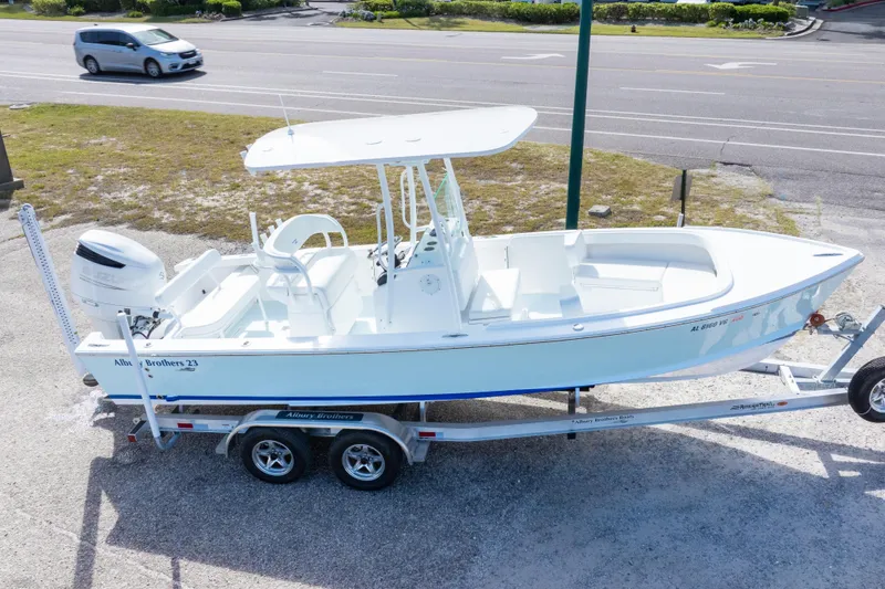 Slide: The Image of 2026 Albury Brothers 23 Forward Seating boat on trailer, parked near a road. - 14