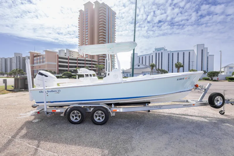 Slide: The Image of 2026 Albury Brothers 23 Forward Seating boat on trailer, urban backdrop, clear sky. - 16