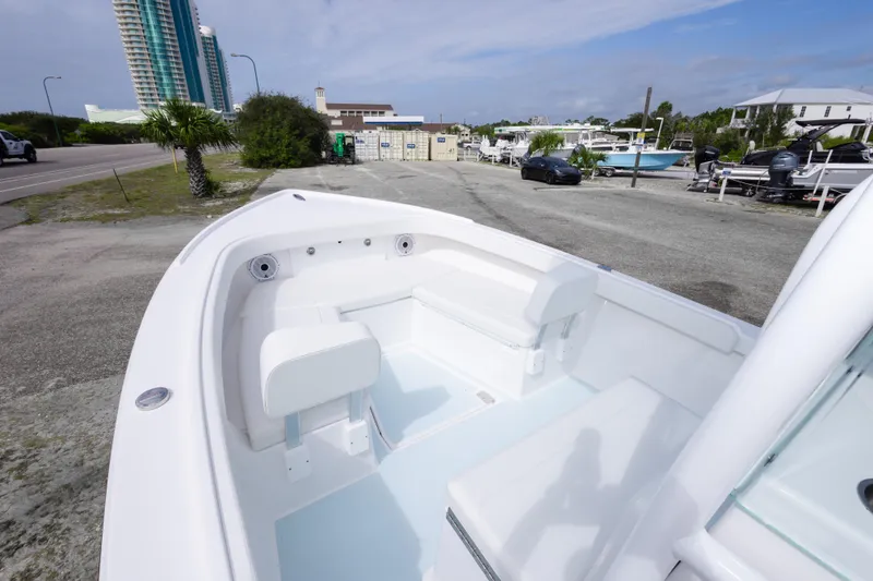 Slide: The Image of 2026 Albury Brothers 23 Forward Seating boat with white interior, parked near coastal buildings. - 35