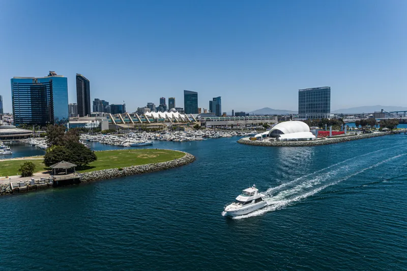 Slide: The Image of 1999 Carver 530 Voyager Pilothouse cruising in a vibrant city harbor with skyline views. - 12
