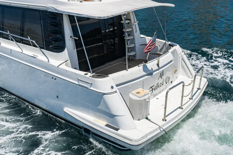 Slide: The Image of 1999 Carver 530 Voyager Pilothouse yacht cruising on water, rear view. - 2