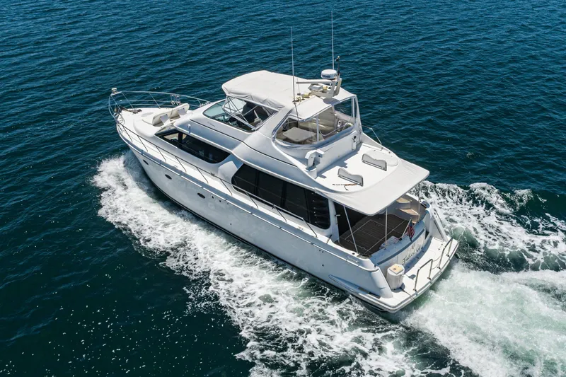Slide: The Image of 1999 Carver 530 Voyager Pilothouse yacht cruising on open water. - 25