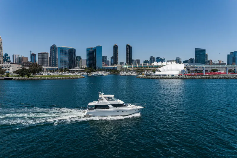 Slide: The Image of 1999 Carver 530 Voyager Pilothouse yacht cruising in urban waterfront with city skyline. - 26
