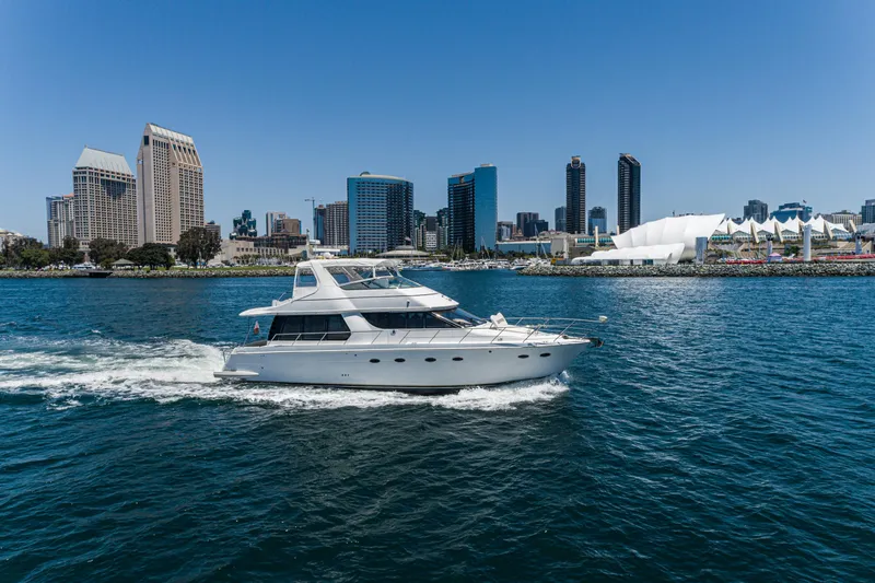 Slide: The Image of 1999 Carver 530 Voyager Pilothouse yacht cruising near city skyline. - 27