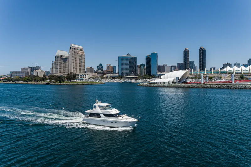 Slide: The Image of 1999 Carver 530 Voyager Pilothouse yacht cruising near city skyline and waterfront. - 28