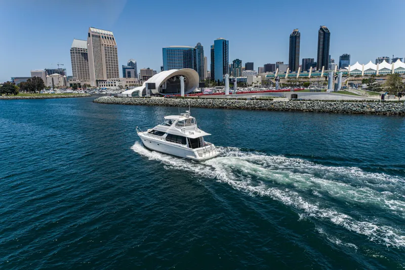 Slide: The Image of 1999 Carver 530 Voyager Pilothouse yacht cruising near city skyline and waterfront. - 30