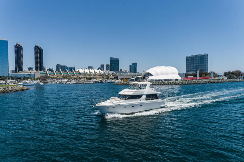 Slide: The Image of 1999 Carver 530 Voyager Pilothouse yacht cruising near city skyline. - 31