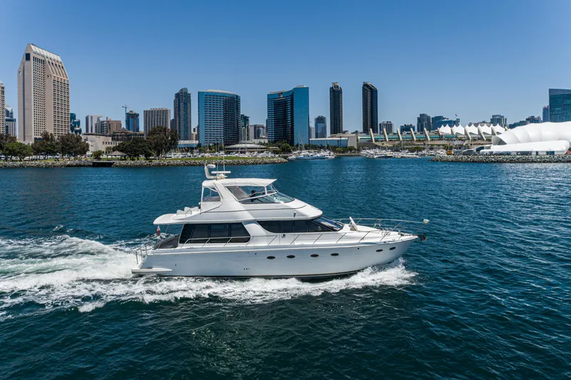 Slide: The Image of 1999 Carver 530 Voyager Pilothouse yacht cruising near city skyline on a sunny day. - 44